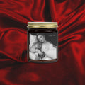 Candle jar with a black and white image of a woman on a red fabric background