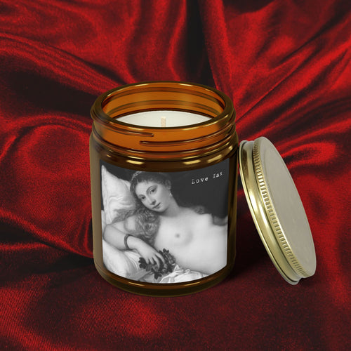 Candle in a jar with a printed design on a red fabric background
